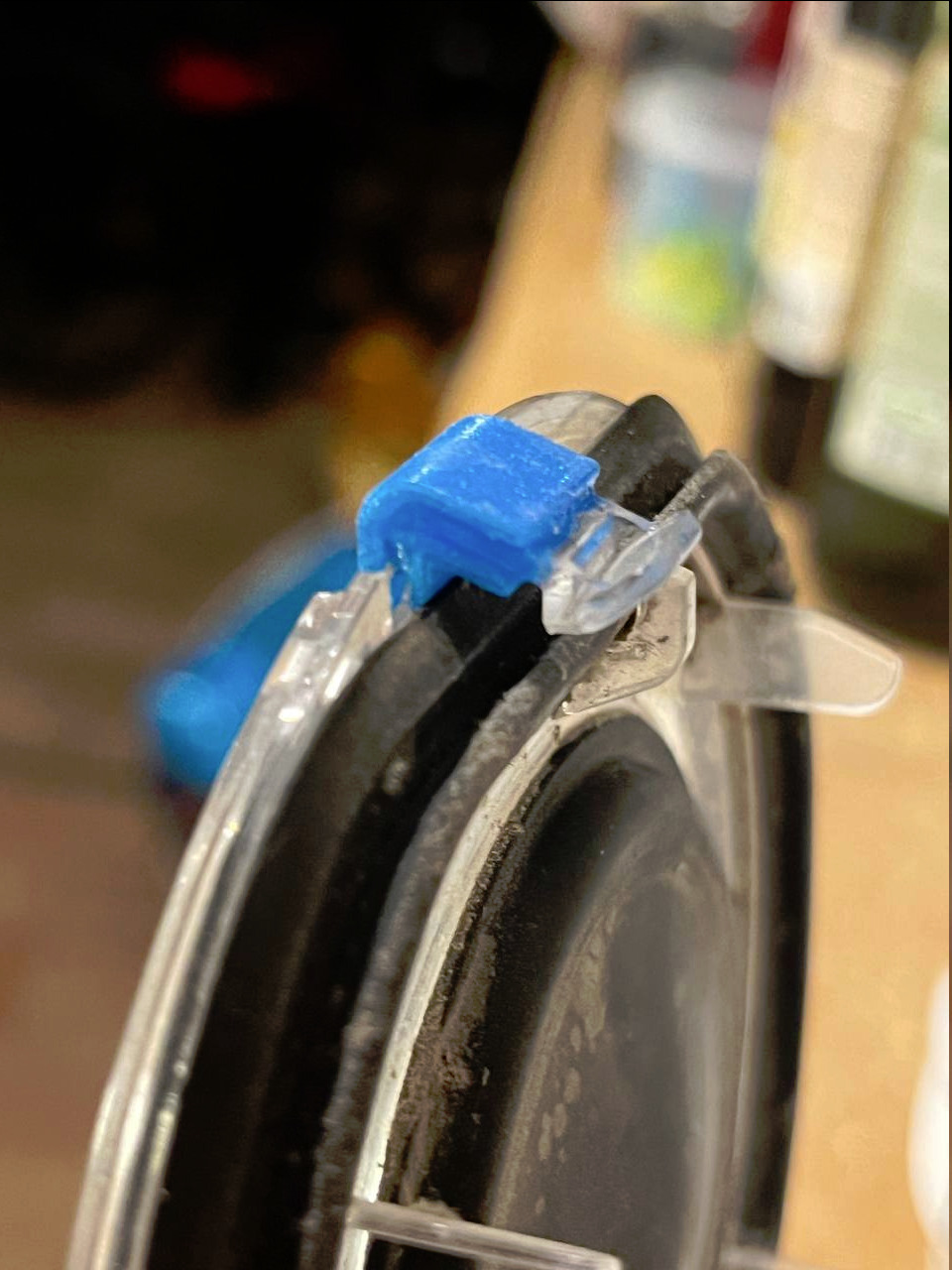 La pièce en plastique bleue collée afin de remettre ensemble les 2 éléments du clip cassé